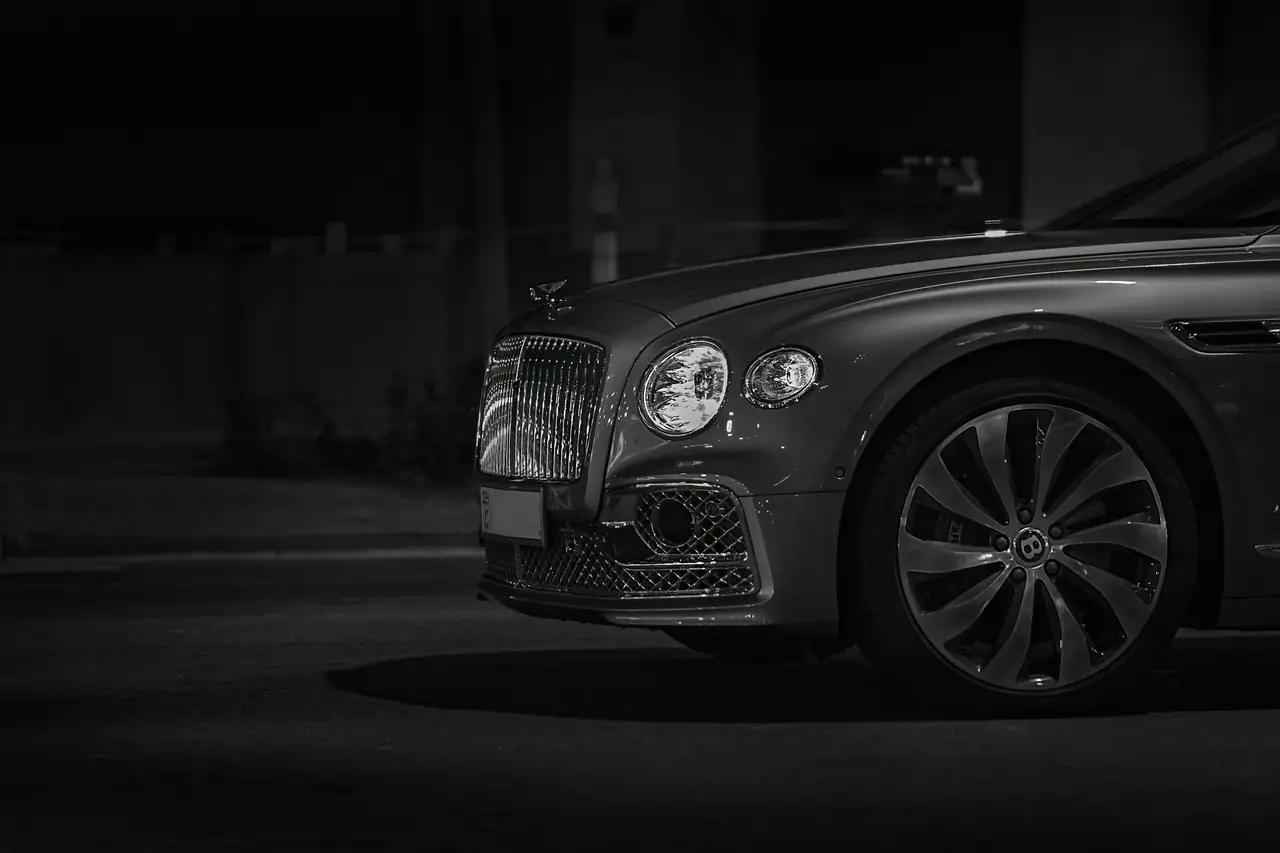 Frontale di una Bentley grigio scuro di notte